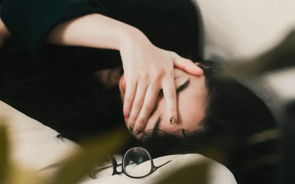 A woman wearily cover's her eyes - exhausted